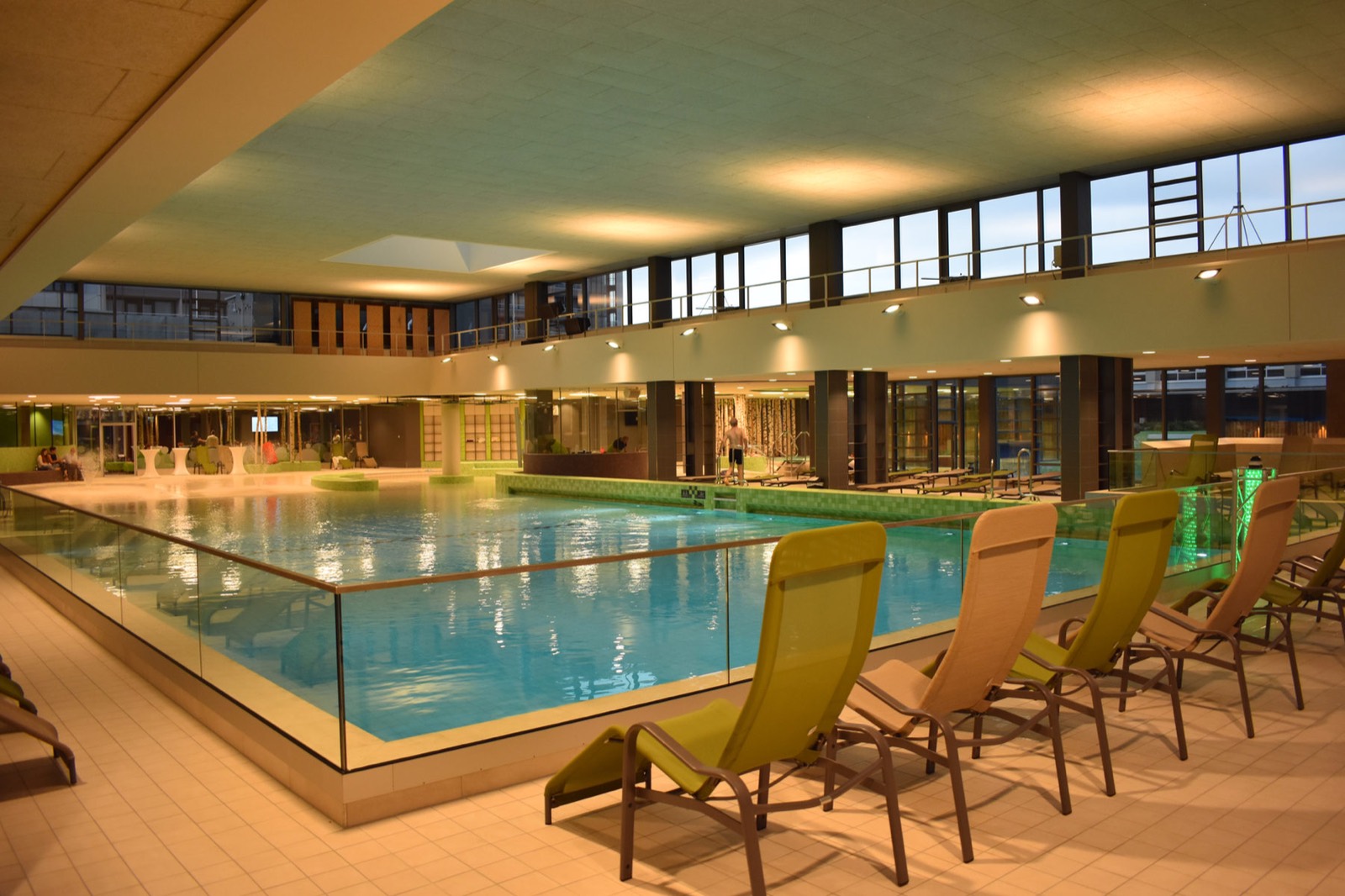Von Heidrich Fliesen gefliestes Hallenbad mit Liegen am Beckenrand